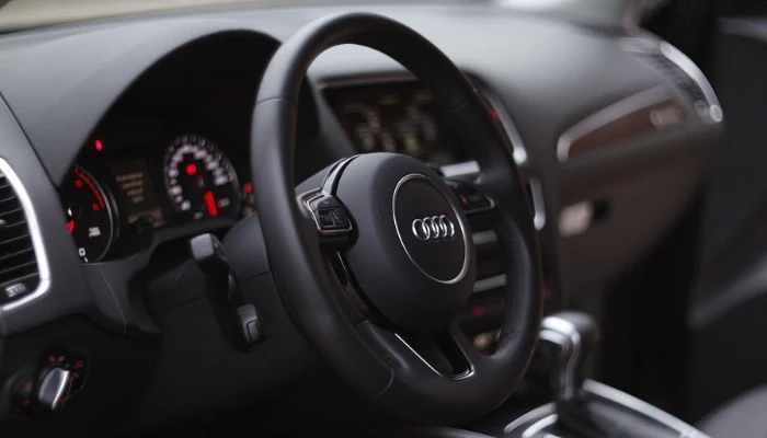 Volante e painel de um veículo Audi para representar a palavra-chave como economizar no audi.