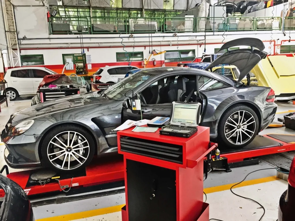 Carro importado na cor cinza escuro recebendo manutenção. Falando sobre manutenção de carros importados.