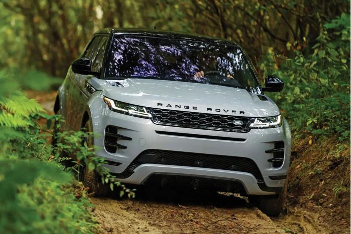 Range Rover em tom de cinza, passando por estrada rural. Falando sobre manutenção de carros importados.