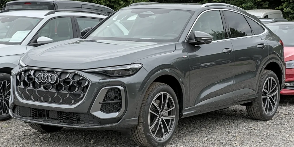 Carro cinza estacionado junto a outros em uma rua de pedras para representar a palavra-chave seguro audi q5.