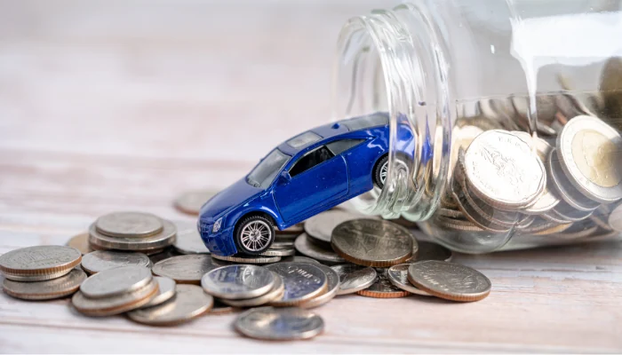 Pote de vidro com moedas saindo junto com um carro de brinquedo para representar a palavra-chave seguro t-cross economizar.