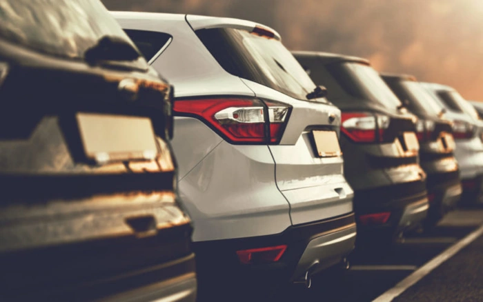 Vários carros estacionados. É possível ver a traseira deles. Explicando como fazer um consórcio de carros.