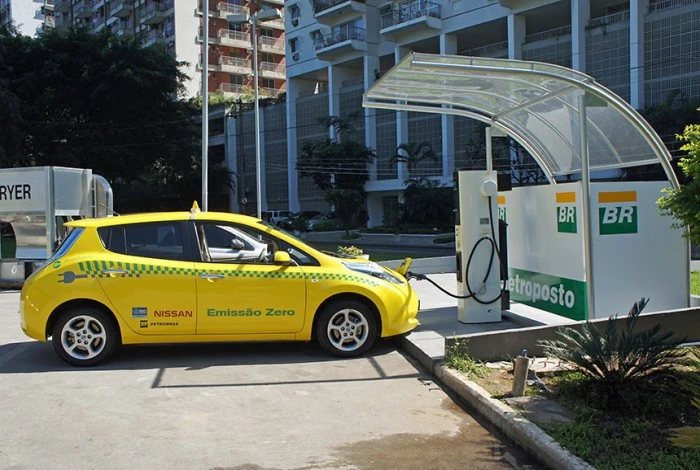Carro amarelo parado em ponto de carregamento da Petrobras. Falando sobre seguro de carro elétrico.