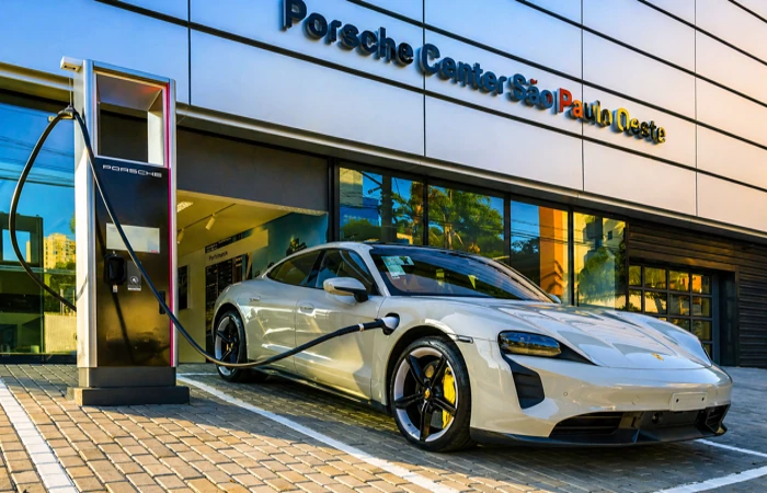 Seguro para carros de luxo é mais caro em quais cidades Porsche elétrico em estação de recarga